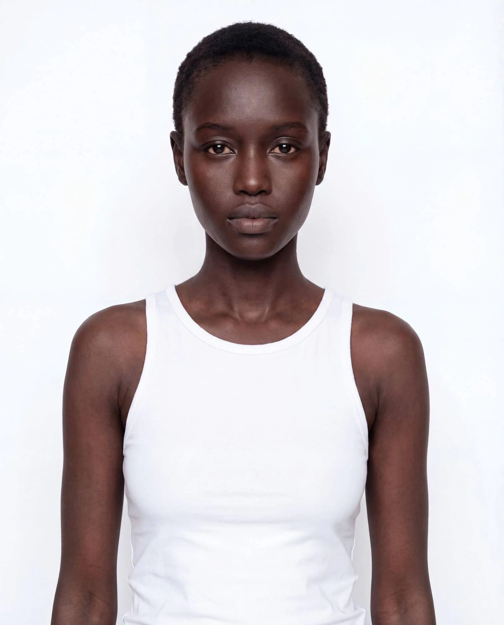 Virtual model, woman with close-cropped black hair, in a white tank top