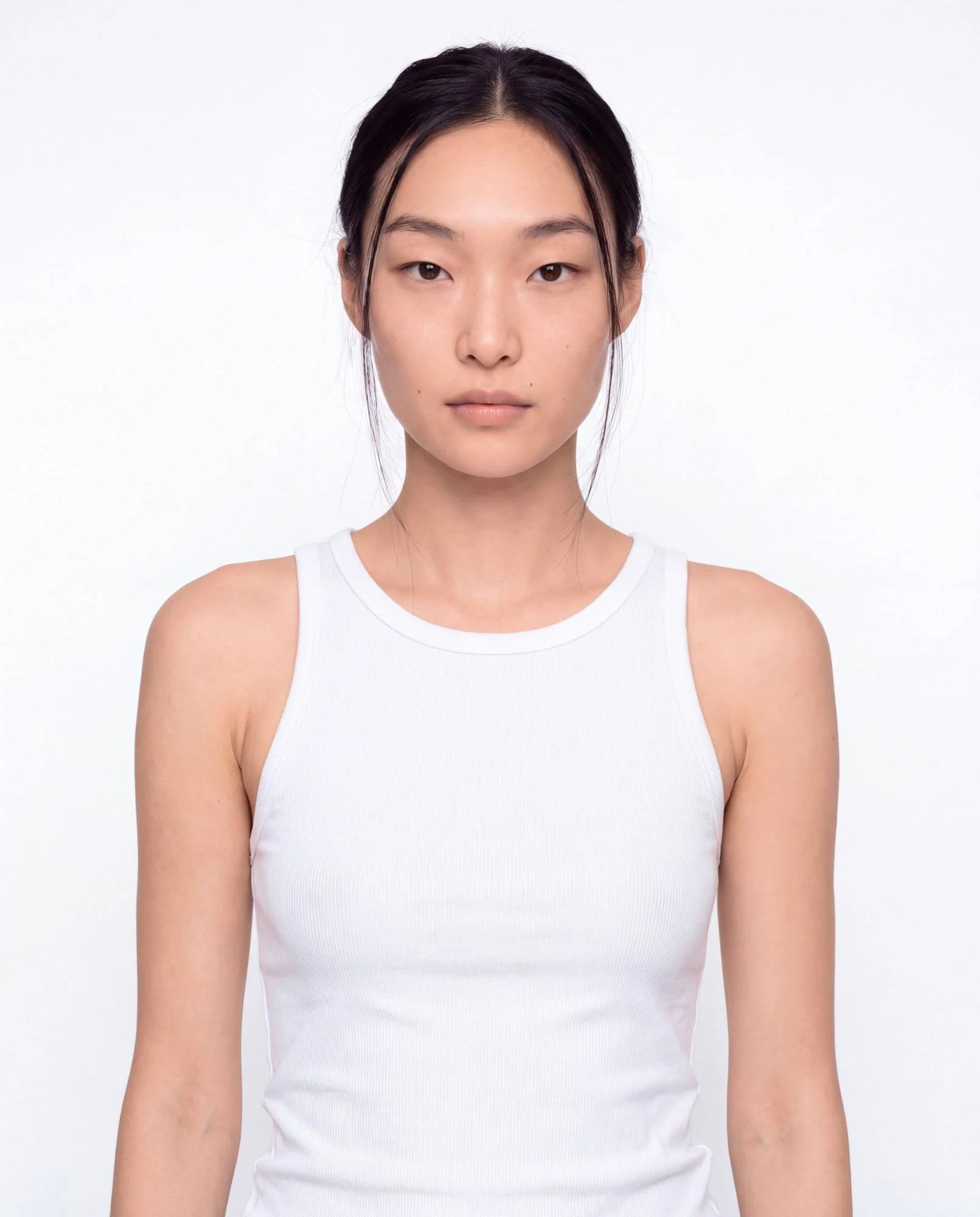 Virtual model, woman with black hair pulled back, in a white tank top