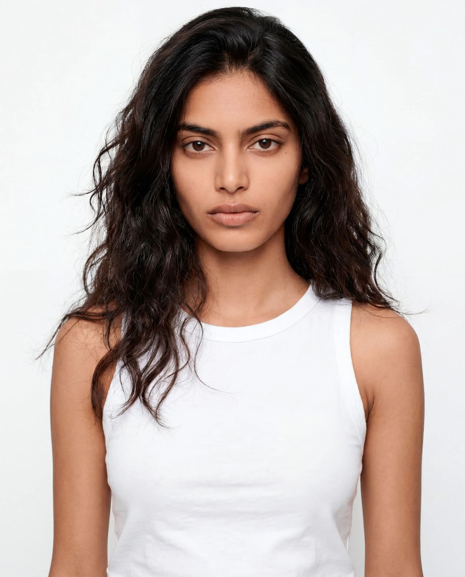Virtual model, woman with long dark wavy hair, in a white tank top