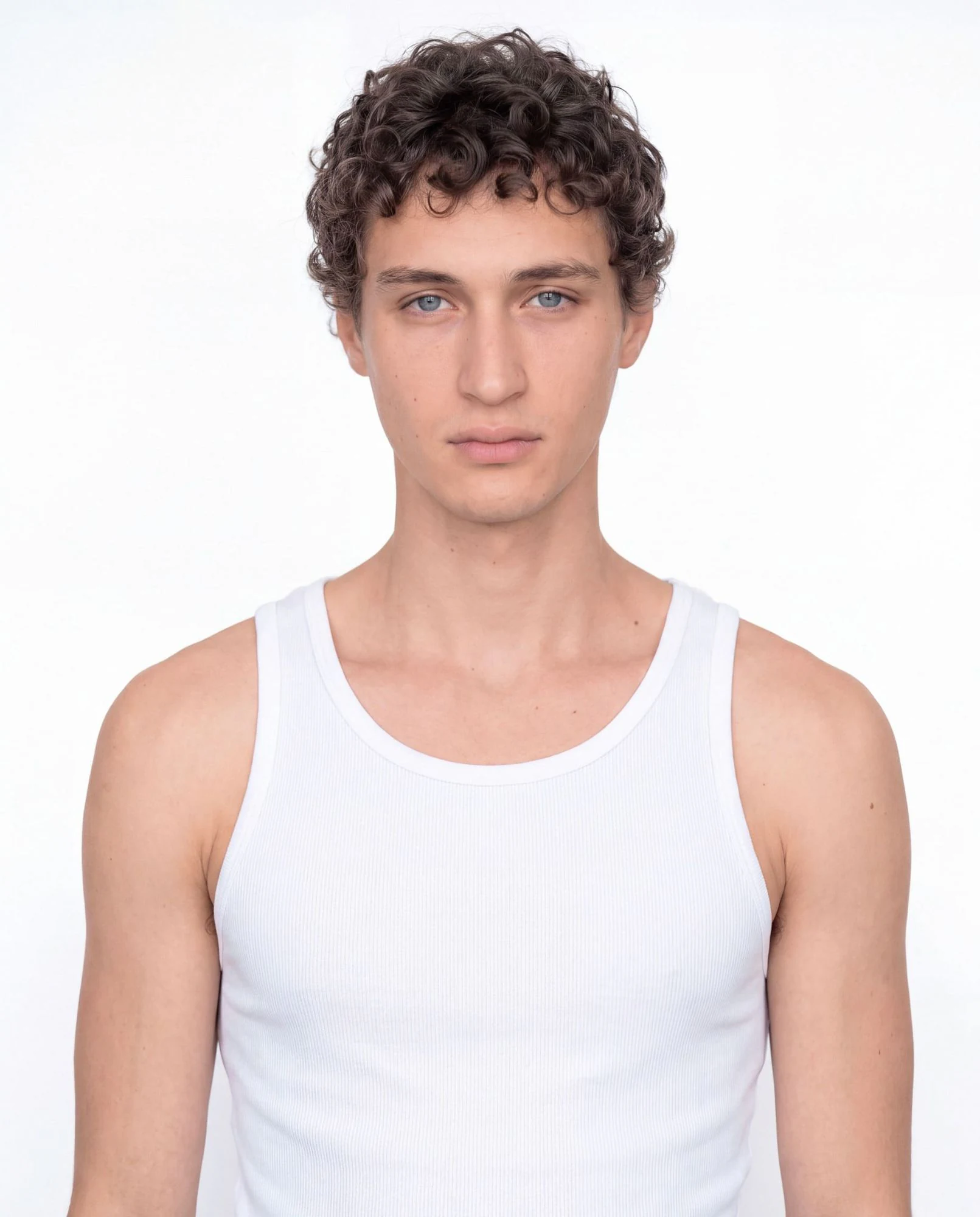 Virtual model, man with brown curls and blue eyes, in a white tank top