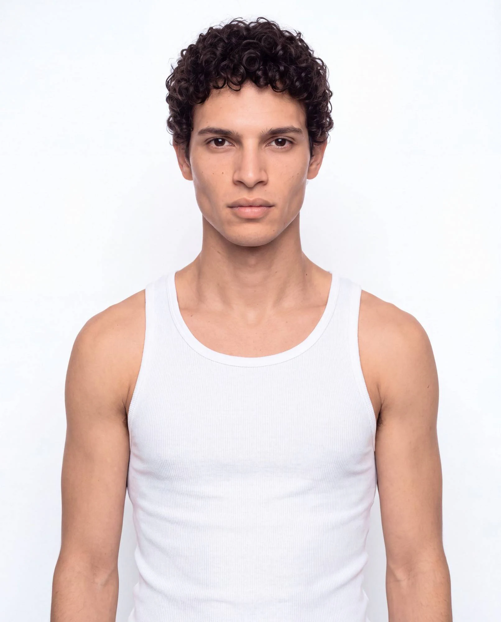 Virtual model, man with dark curls and a light moustache, in a white tank top