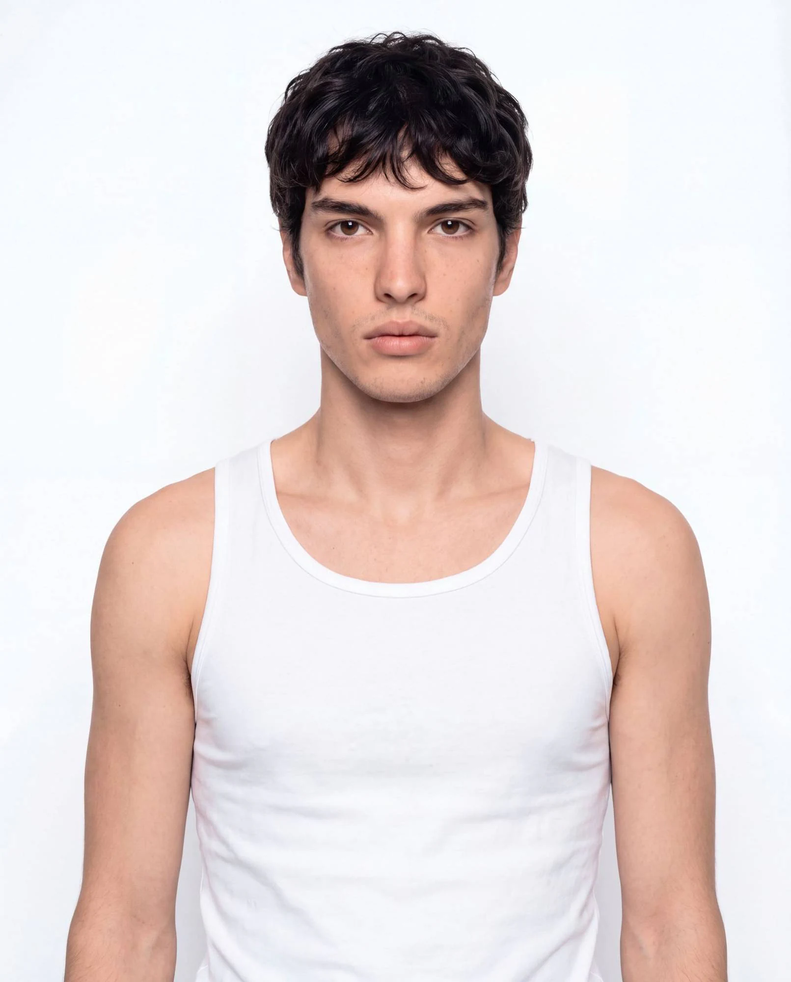 Virtual model, man with dark wavy hair, in a white tank top