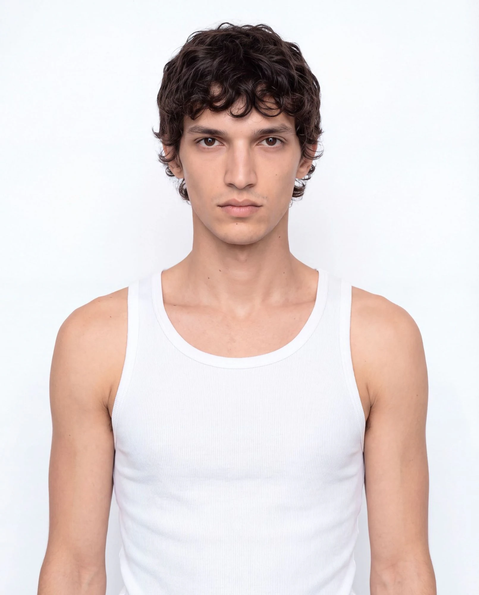 Virtual model, man with short black curls, in a white tank top