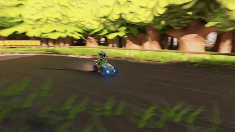 A rider drifting a blue mower around a dirt track lined with trees