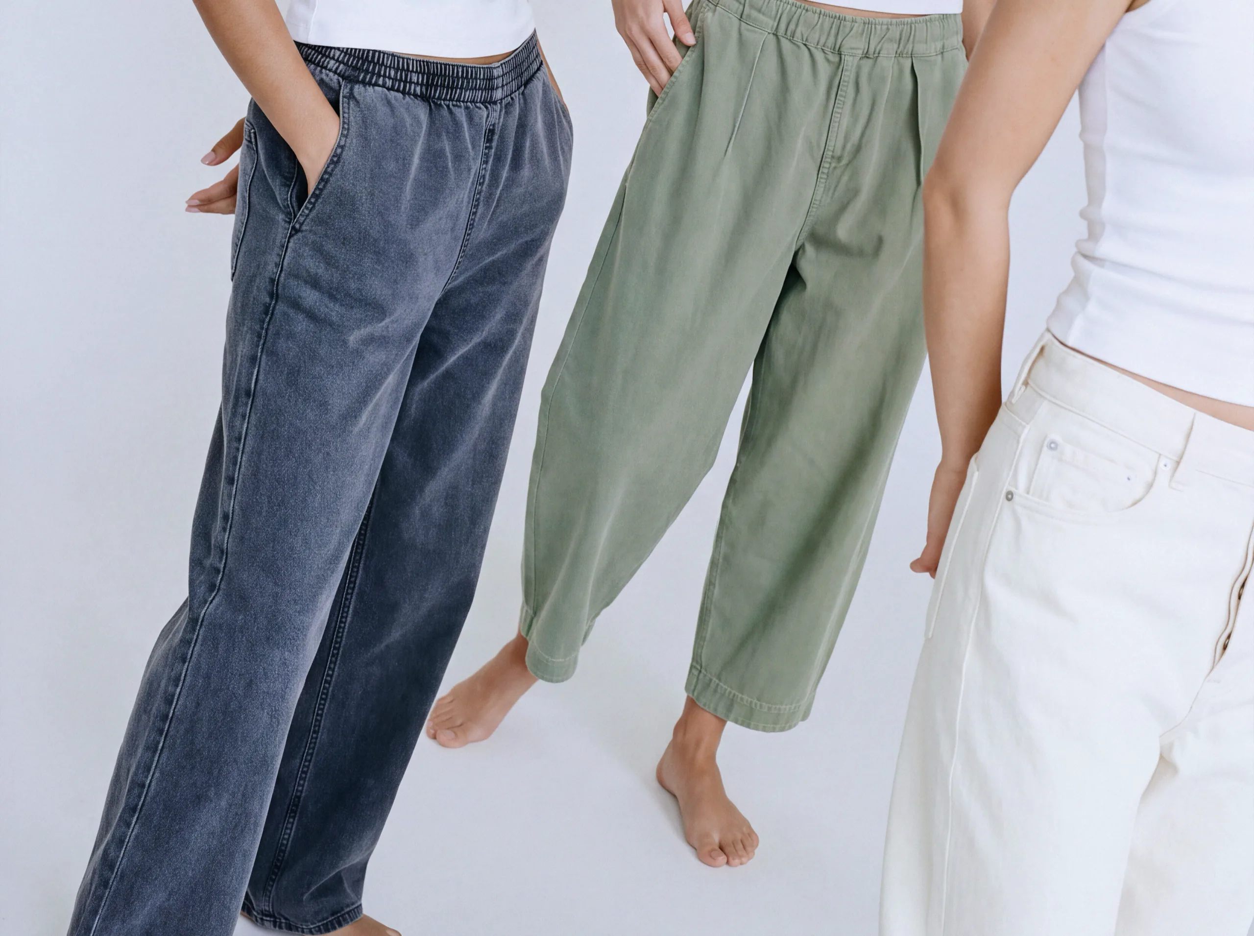 Three models in blue, sage green and cream American Vintage trousers with white tank tops