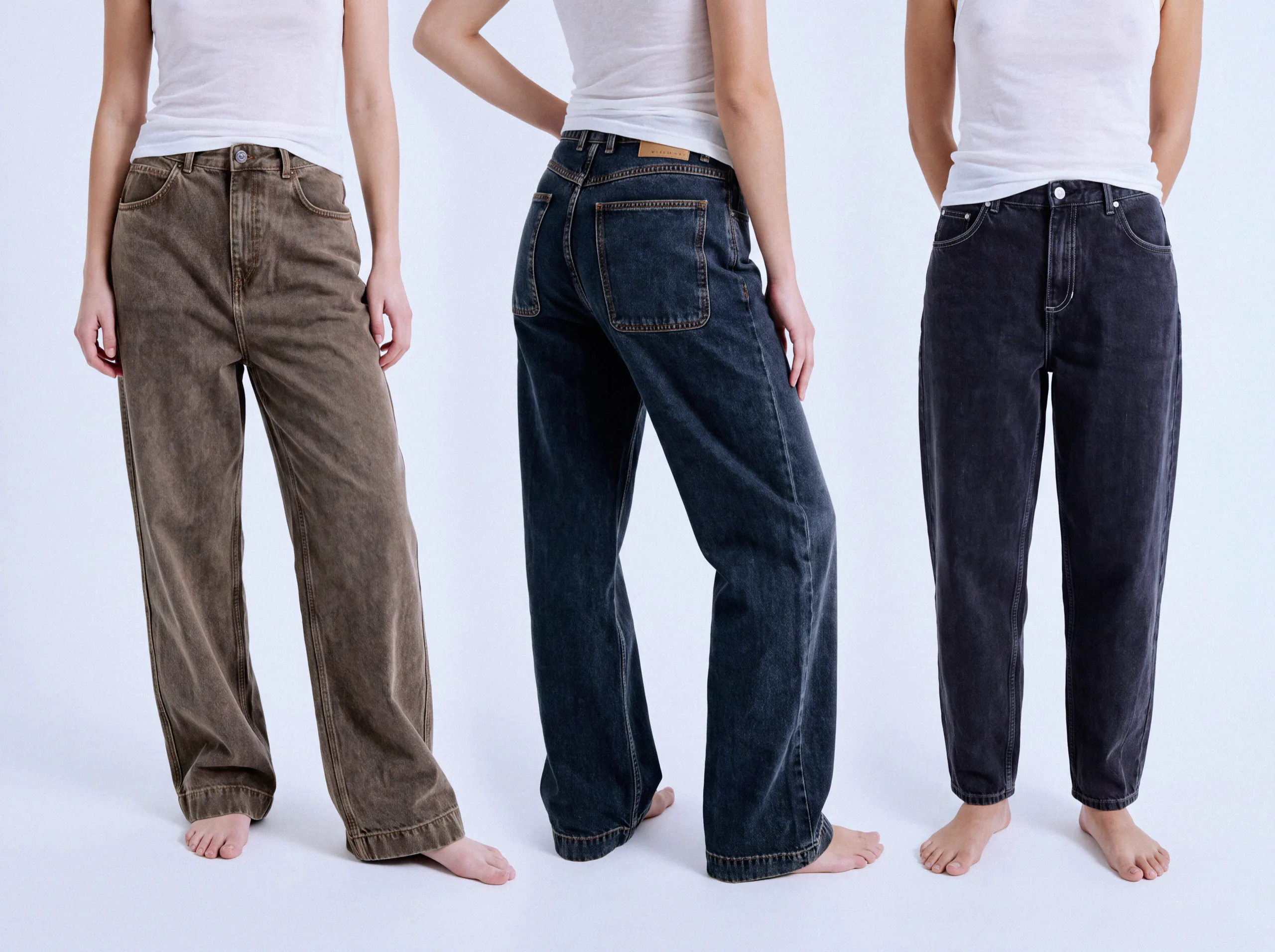 Trois mannequins en jeans American Vintage marron, bleu foncé et noir avec des débardeurs blancs