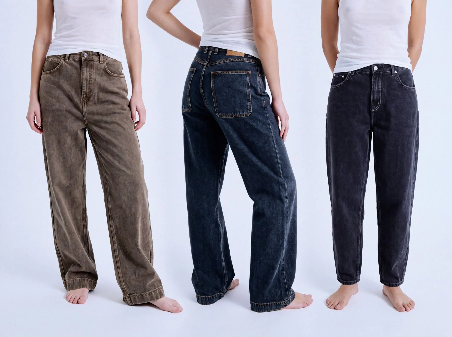 Three pairs of American Vintage jeans in brown, washed black and charcoal, worn with white tank tops
