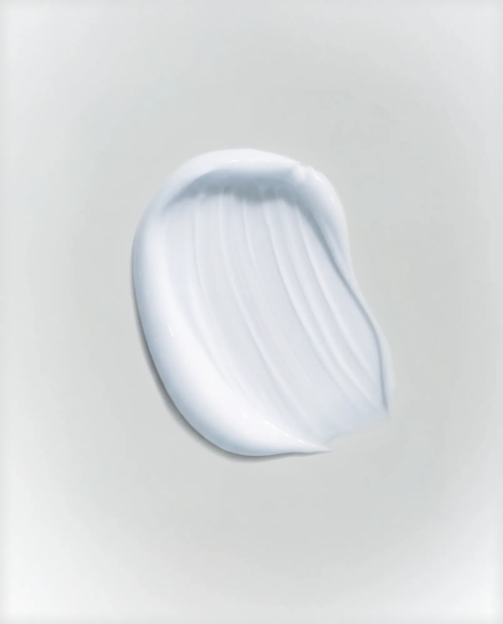 Swatch of white cream on a pale surface