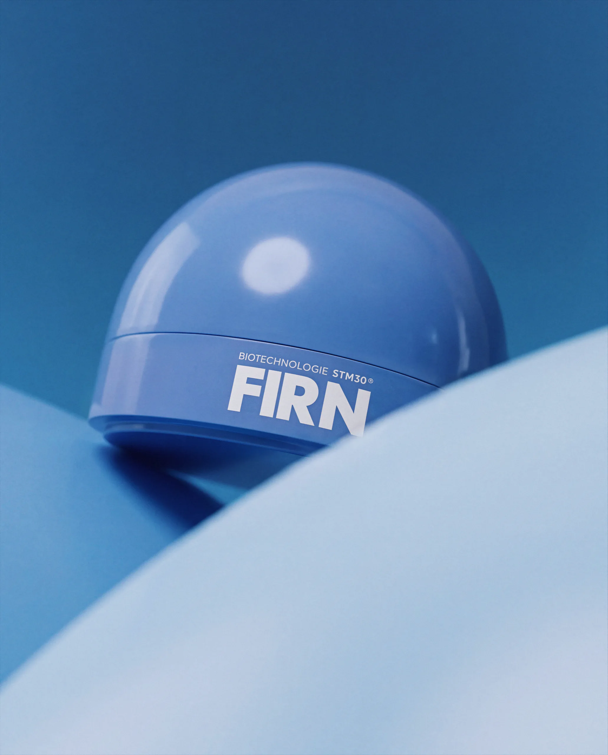 Blue Firn skincare jar on a curved pale blue surface