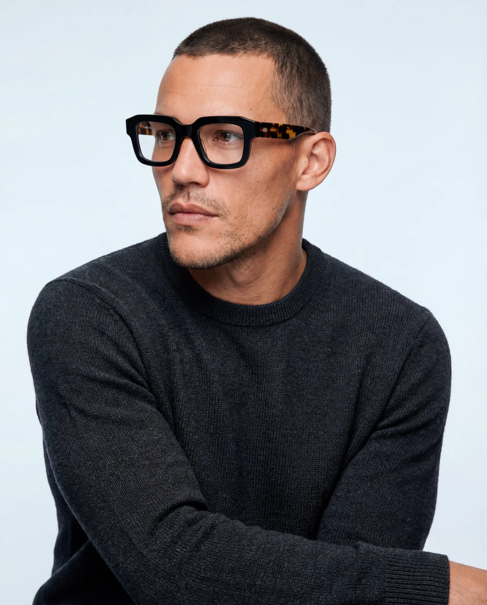 Man in a black sweater wearing thick black frames